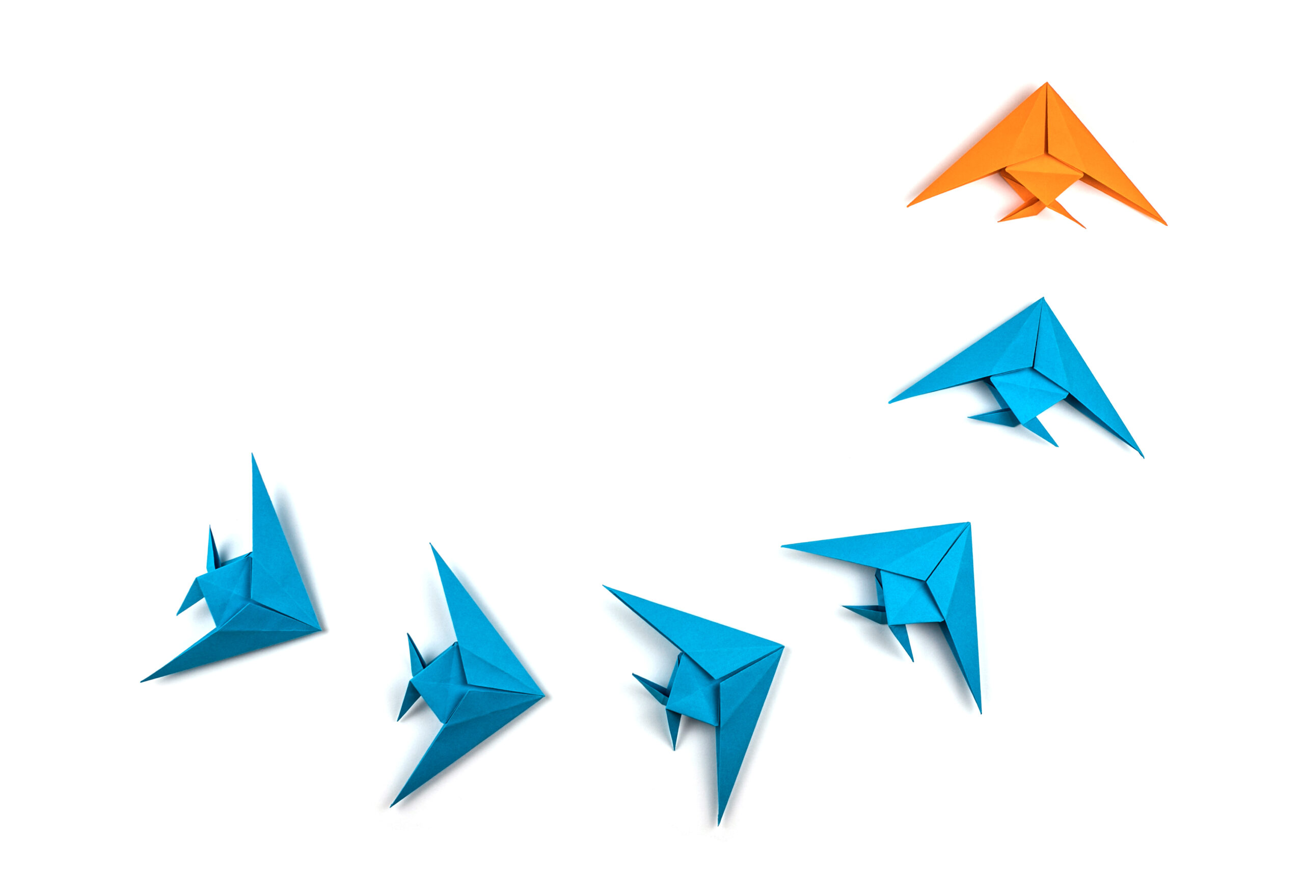 A group of origami fish are flying in the air.